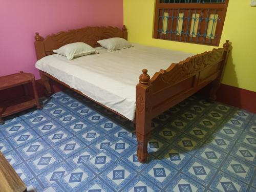 1 dormitorio con 1 cama y suelo de baldosa azul en Niraloy en Bolpur