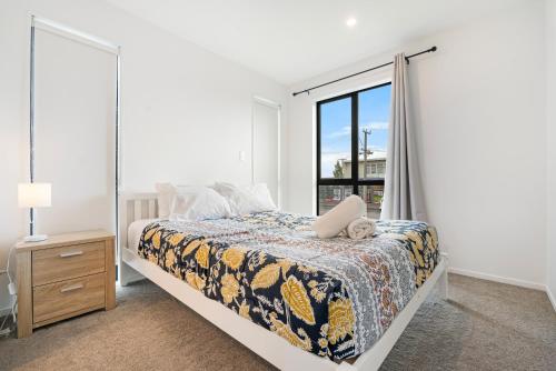 a bedroom with a bed and a window at Cozy Brand New Townhouse 20 in Auckland
