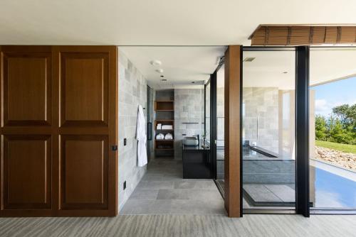 a bathroom with a glass door leading to a sink at GOTO RETREAT by Onko Chishin in Goto