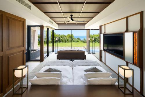 a bedroom with a bed and a view of the ocean at GOTO RETREAT by Onko Chishin in Goto