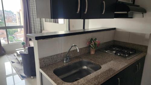 un bancone della cucina con lavandino e piano cottura di Apartamento central a Medellín