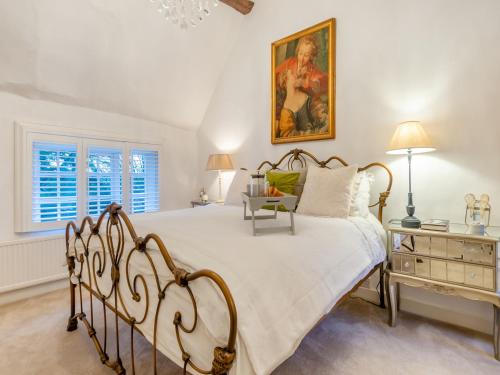a bedroom with a bed and a painting on the wall at The Cottage in Hungerton