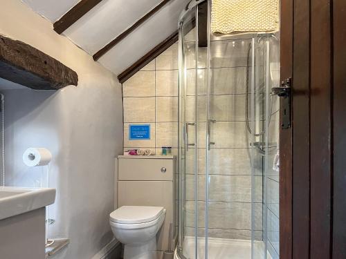 a bathroom with a toilet and a glass shower at Sienna Cottage - W7764 in Monyash