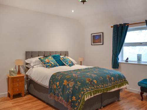 1 dormitorio con cama y ventana en Swallow Lodge, en Horsington