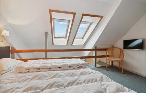 a attic bedroom with a bed and a tv at Amazing Apartment In Allinge With Kitchen in Sandvig