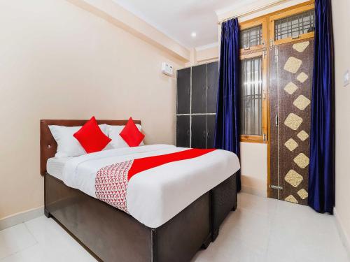 1 dormitorio con 1 cama grande con almohadas rojas en OYO Flagship Kalawati Palace en Bhauli