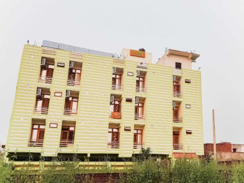 a large yellow building with red windows at OYO Flagship Kalawati Palace in Bhauli