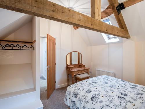 Marchamley的住宿－Northwood Farm Cottage，一间卧室配有一张床、一张书桌和一个窗户。