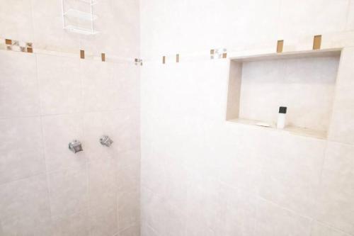 a bathroom with a shower with a white tiled wall at Centro histórico, tranquilo y con terraza in Querétaro