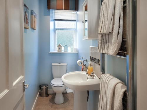 La salle de bains est pourvue de toilettes blanches et d'un lavabo. dans l'établissement Ocean View Retreat, à Pittenweem