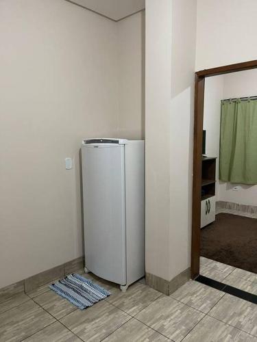 a white refrigerator in a room with a wall at Apartamento próximo ao centro in Primavera do Leste