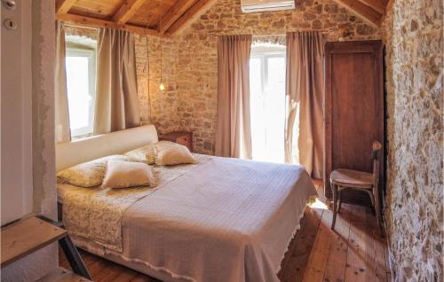 a bedroom with a bed in a room with windows at Cozy Home In Donje Selo With Kitchen in Donje Selo na Šolti