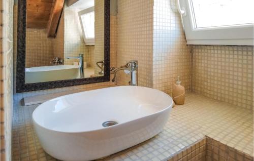 a bathroom with a large white sink and a tub at Cozy Home In Donje Selo With Kitchen in Donje Selo na Šolti