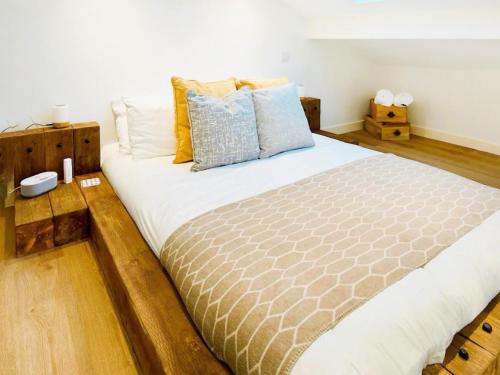 a bedroom with a large bed with wooden floors at Honey Bee Cottage in Welshpool