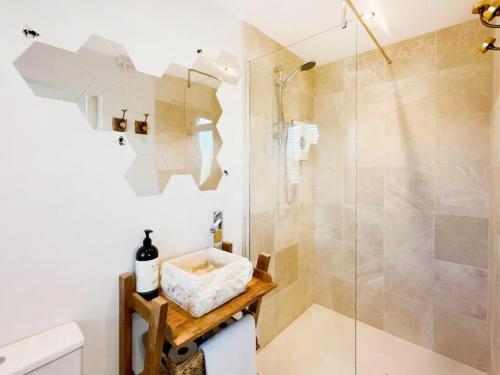a bathroom with a shower with a glass door at Honey Bee Cottage in Welshpool