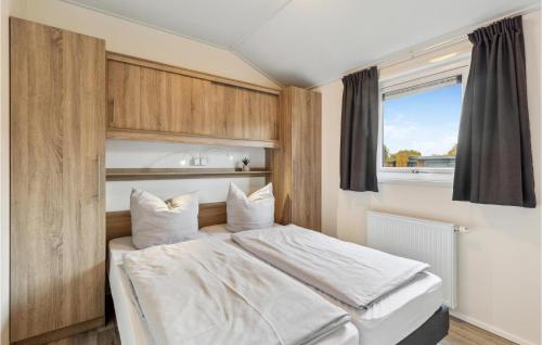 een slaapkamer met een bed met witte lakens en een raam bij Charlet D31 in Süsel