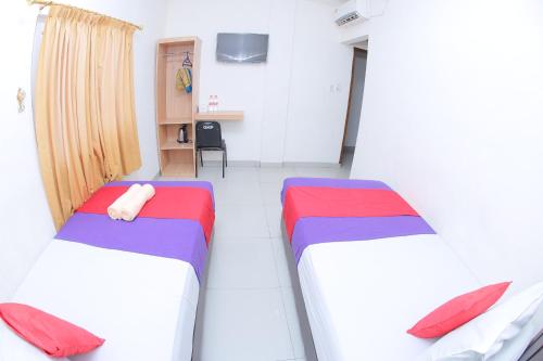 a room with two beds and a desk in it at grand koetaradja permai hotel in Luengbata