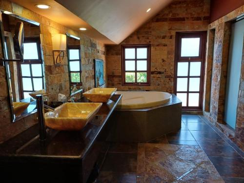 B&B Rosa Dei Venti في Tronadora: حمام كبير مع مغسلتين وحوض استحمام