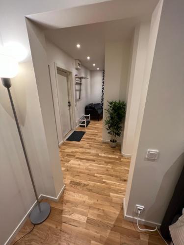 a hallway with a lamp and wooden floors in a building at Noah Longstay Apartment in Västerås