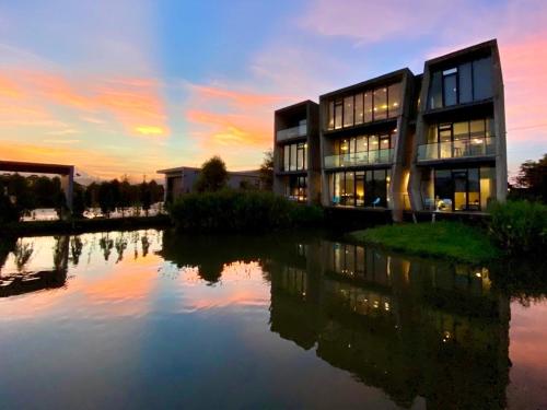 a building with a reflection in the water at sunset at Water with Candle Homestay in Wujie