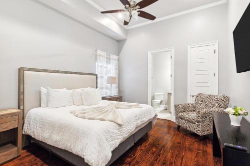 a bedroom with a bed with a ceiling fan and a chair at Amazing 3bedroom townhome, in Historic Dryade City in New Orleans