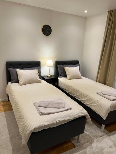 two beds sitting next to each other in a room at Noah Longstay Apartment in Västerås
