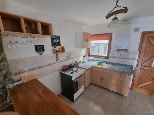 uma cozinha com um fogão e um lavatório em Tu lugar en el fin del mundo em Ushuaia
