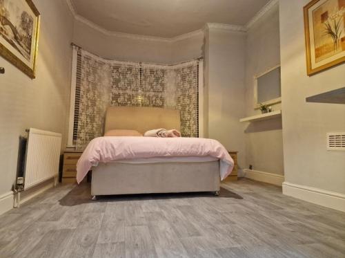 a bedroom with a bed with a pink blanket at ArklesFCLiverpool in Liverpool