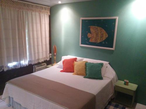 Un dormitorio con una cama con almohadas de colores. en Pousada Algas Marinhas, en Fernando de Noronha