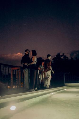 a group of people standing next to a pool at night at Yum Kaax Boutique Villa in Tulum