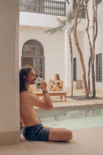 a man sitting on the floor drinking from a wine glass at Yum Kaax Boutique Villa in Tulum