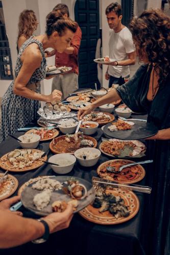 a group of people standing around a table full of food at Yum Kaax Boutique Villa in Tulum