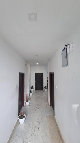 a hallway with three toilets in a white room at Shivaji Inn Kaziranga in Kāziranga