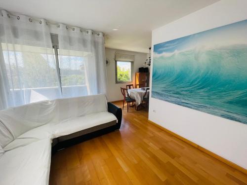 a living room with a white couch and a painting on the wall at Forum Beach in Barcelona