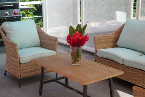 a vase of red flowers sitting on a coffee table at El Yunque Waterfalls Romantic Stay at Casa Parcha in Naguabo