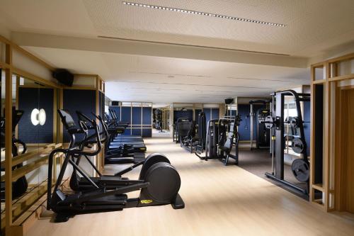 a gym with a row of treadmills and machines at Conrad Singapore Orchard in Singapore