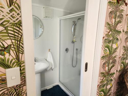 a bathroom with a shower and a sink at 'Haumoana' in Olde Beach. in Waikanae