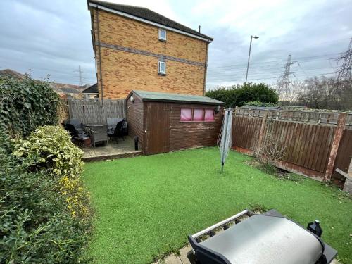 a small yard with a fence and a building at Entire 3 bedroom end of terrace house! in Thamesmead