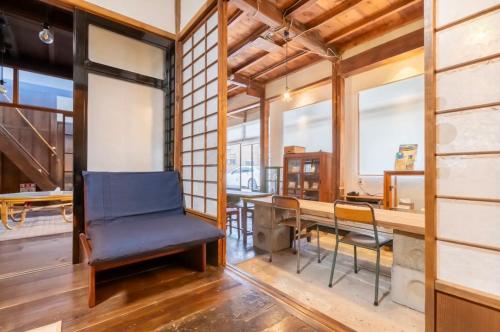 a dining room with a blue chair and a table at 囲炉裏町家Guesthouse FUJITA 一棟貸切 villa 無料駐車場 in Hakusan