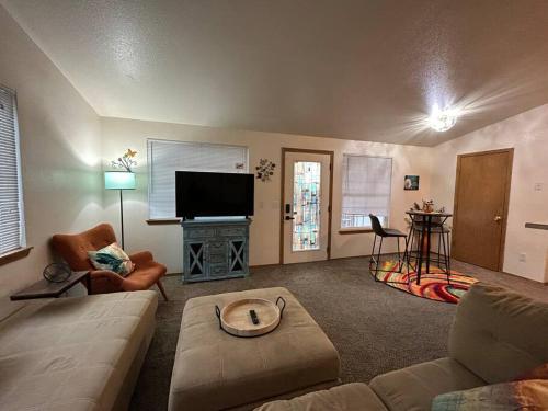 a living room with a couch and a flat screen tv at Clyde's Crib: Cozy Ms. Pac-Man in Boise