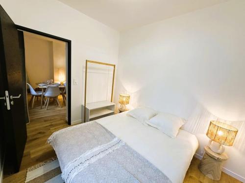 a bedroom with a bed with a mirror and a table at L'Escapade des Privilégiés in Amiens