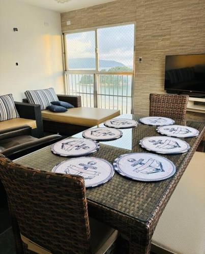 a table with plates on it in a living room at Apartamento espaçoso com vista deslumbrante in São Vicente