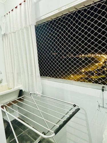 a shopping cart sitting in front of a window at Apartamento espaçoso com vista deslumbrante in São Vicente