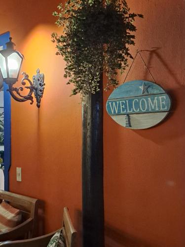a pole with a welcome sign next to a wall at Hotel Liberdade Búzios in Búzios