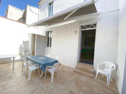 d'une terrasse avec une table bleue et des chaises blanches. dans l'établissement Spacieux Pavillon T5 avec Cour Privée et WiFi, à 150m de la Grande Plage aux Sables d'Olonne - FR-1-92-922, à Les Sables-dʼOlonne