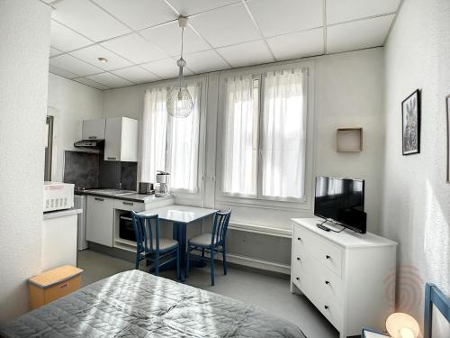 uma cozinha com mesa e cadeiras num quarto em Studio Lamalou-les-Bains, 1 pièce, 2 personnes - FR-1-451-179 em Lamalou-les-Bains