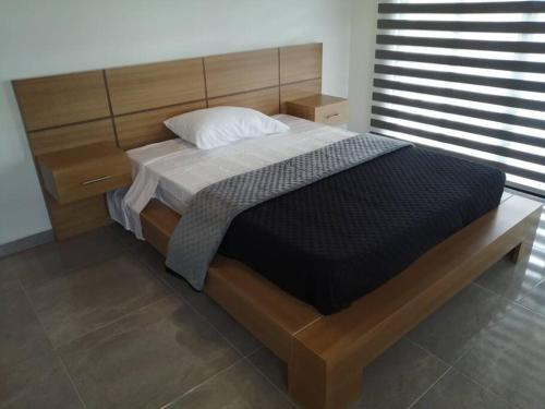 una camera con un grande letto con testiera in legno di Vista Club View a Florián