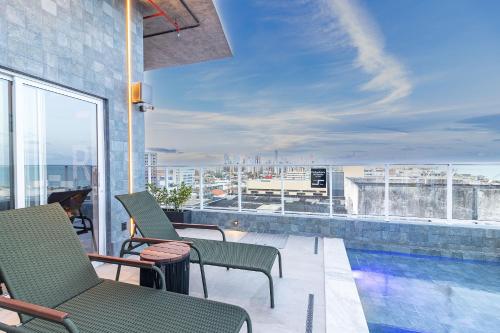 een balkon met stoelen en een zwembad in een gebouw bij Place2You Hotel by Welkom in João Pessoa