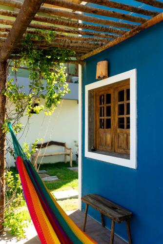 a hammock in front of a blue house at Pousada Carcará in Fortim