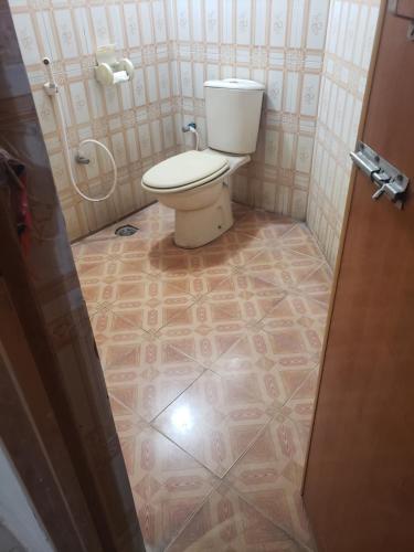 a bathroom with a toilet and a tiled floor at Private double room with attached bathroom nikunja 2 in Dhaka